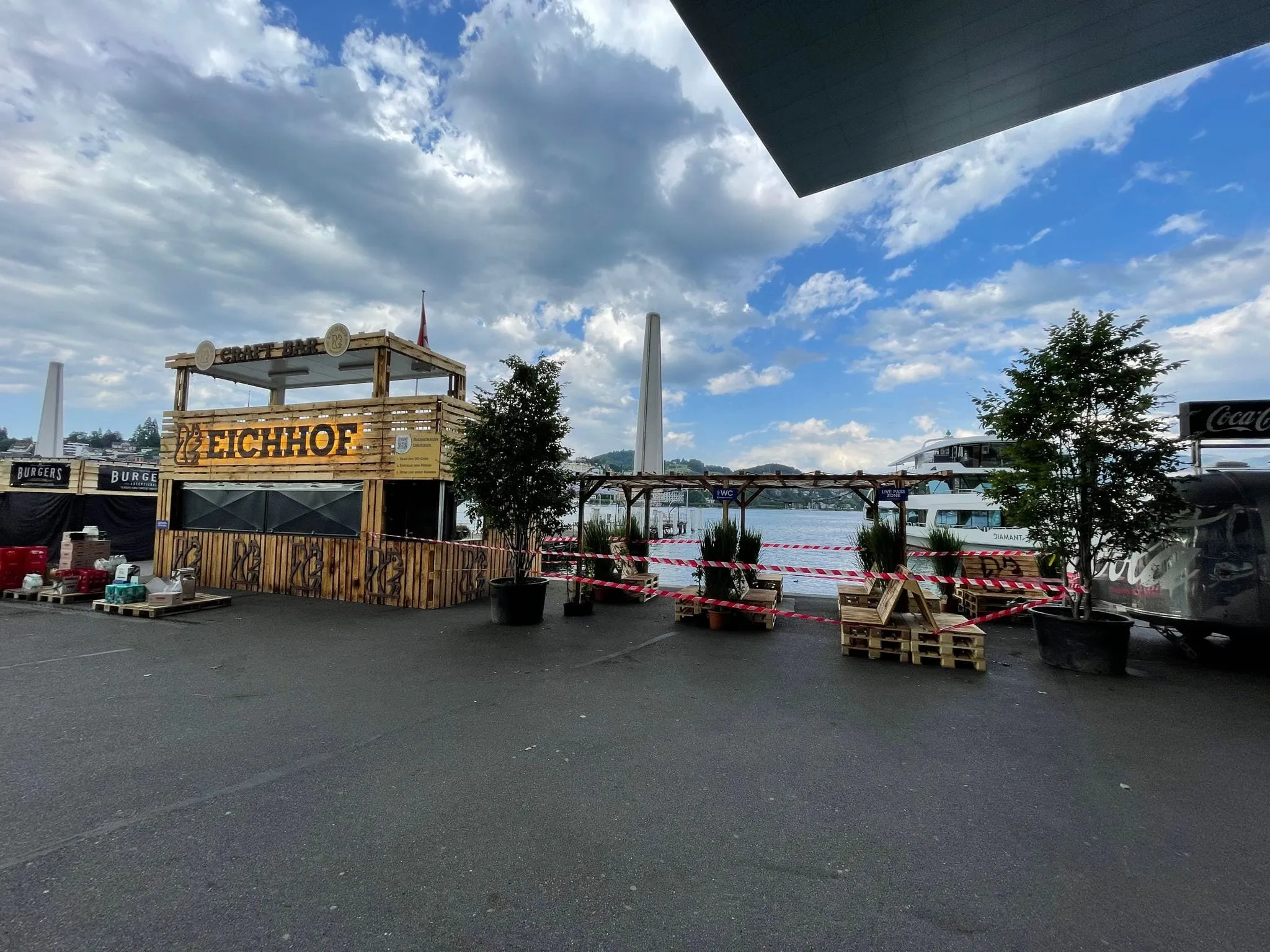 Eichhof Craft Bar made from pallet wood, with a roof terrace, pergola and potted trees on the shore of Vierwaldstättersee
