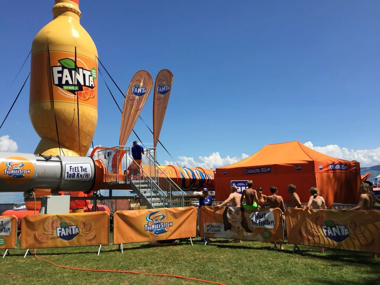 Aufblasbare Fanta-Flasche, Windturbine mit Schriftzug «Feel the 100 km/h», Beachflags und Changing-Room-Zelt