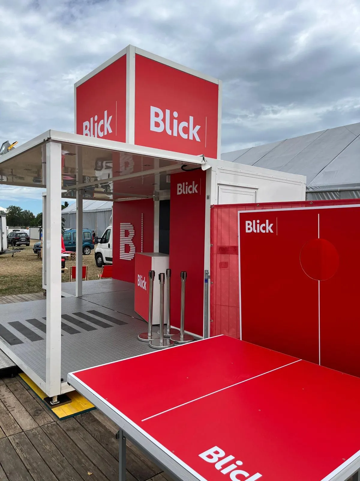 Roter Blick Cube mit Ping-Pong-Tisch, Wurfwand mit Loch und einem B aus Tischtennisbällen im Innern