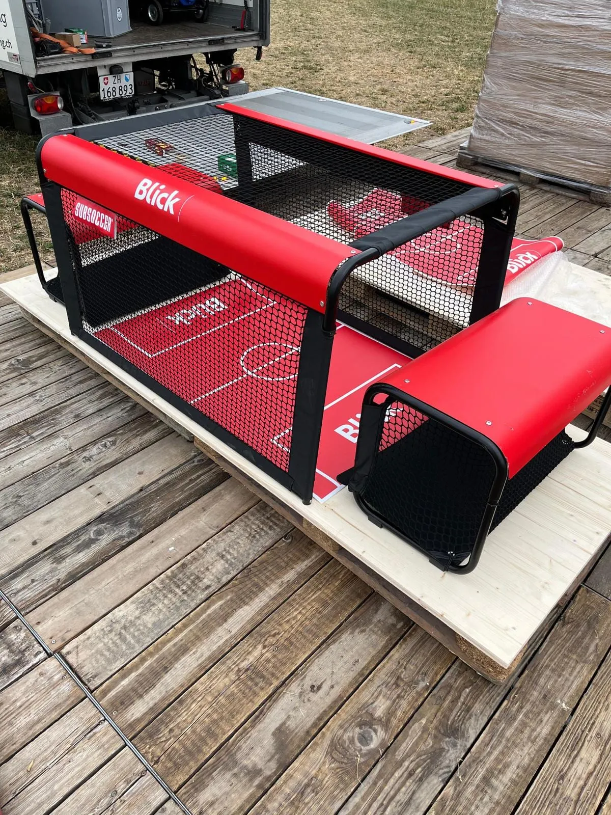 Rotes Subsoccer-Tischfussballspiel mit Blick-Branding und Netz auf einer Palette vor dem Lieferwagen