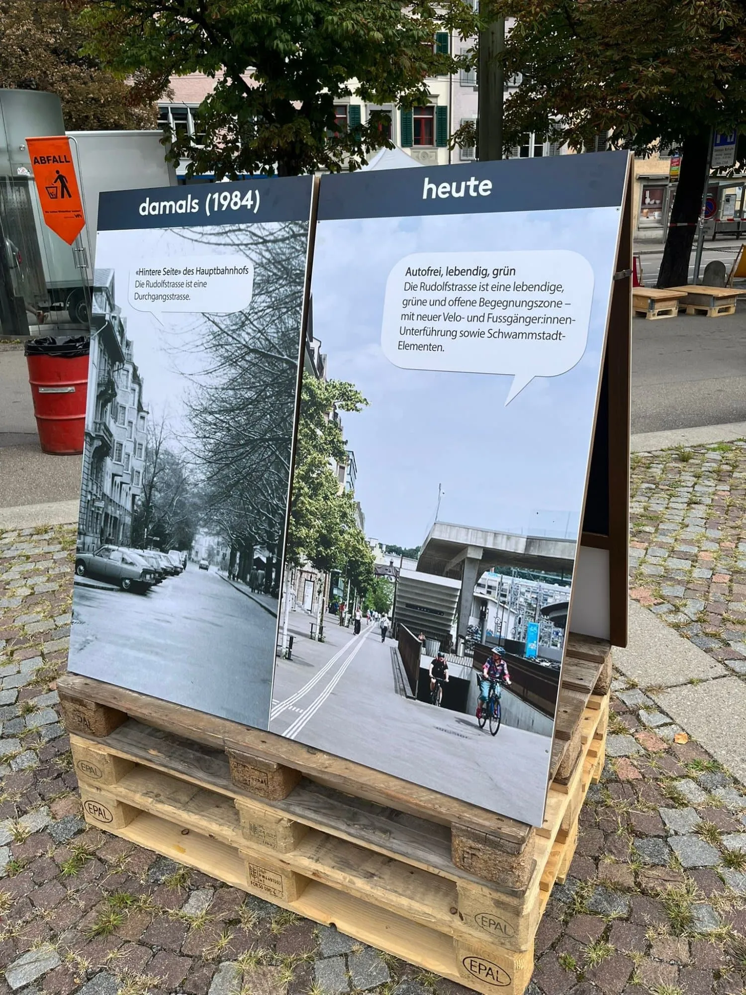Tafel auf Paletten mit Schwarzweissfoto der Rudolfstrasse von 1984 und Foto der heutigen Begegnungszone