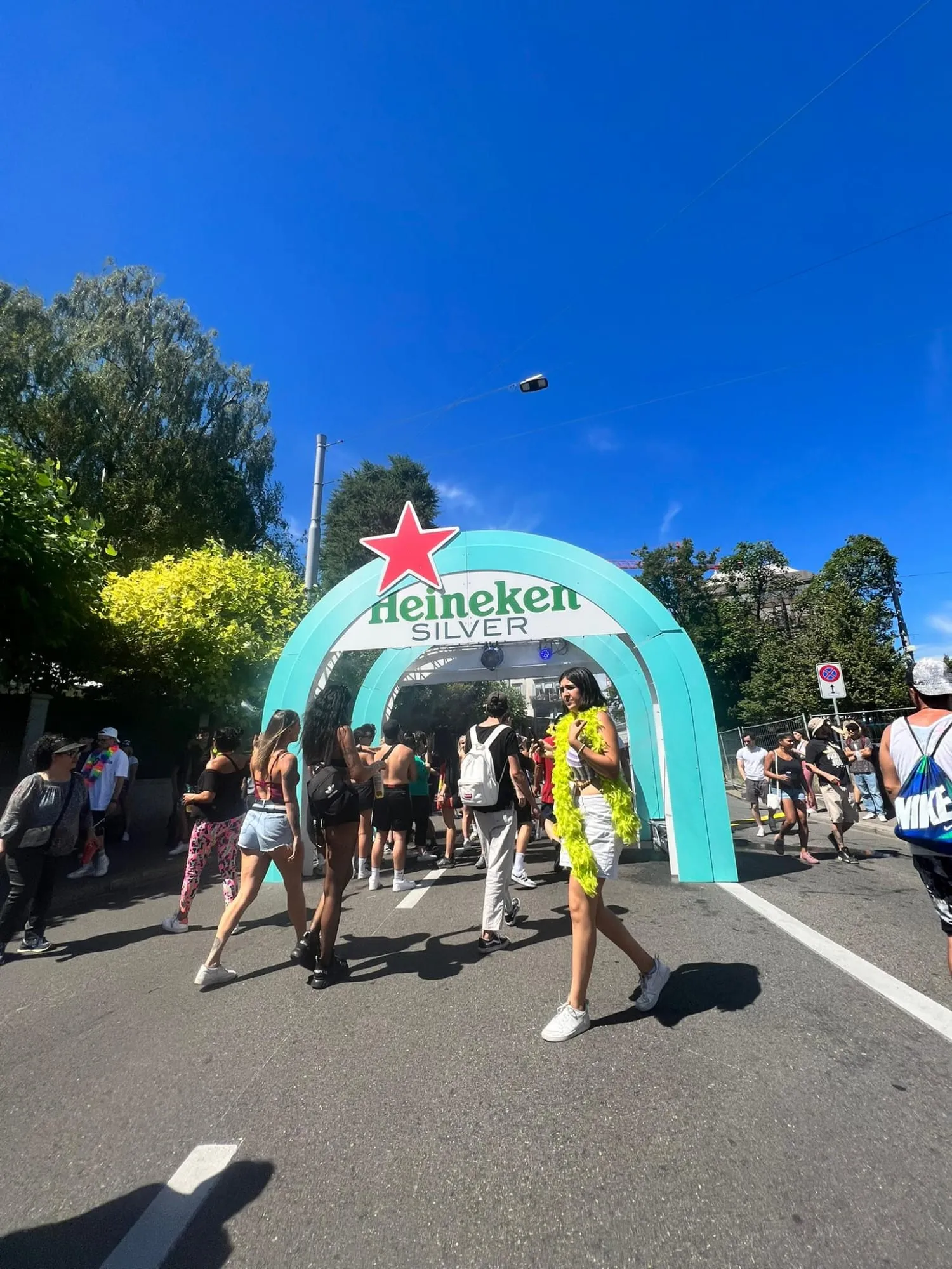 Fertiger Heineken-Silver-Bogen mit rotem Stern über der Strasse, Besuchende der Street Parade gehen hindurch