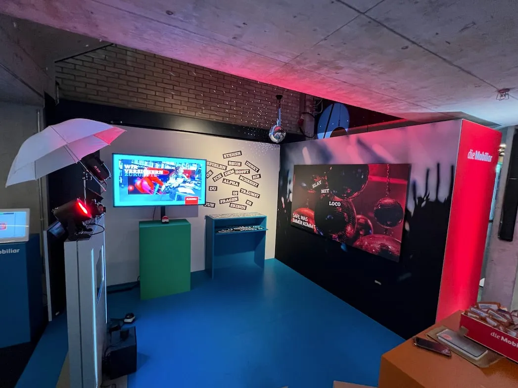 Inside the Mobiliar stand with a screen, buzzer pillar, disco ball and red and blue lighting