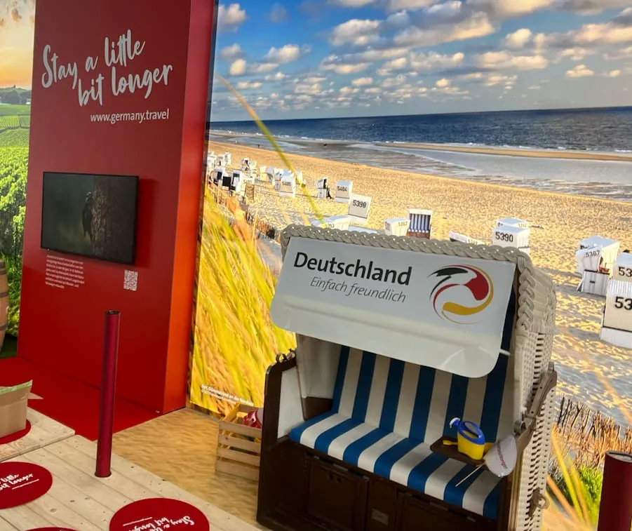 Blau-weiss gestreifter Strandkorb mit Deutschland-Logo vor einer Fotowand mit Nordseestrand