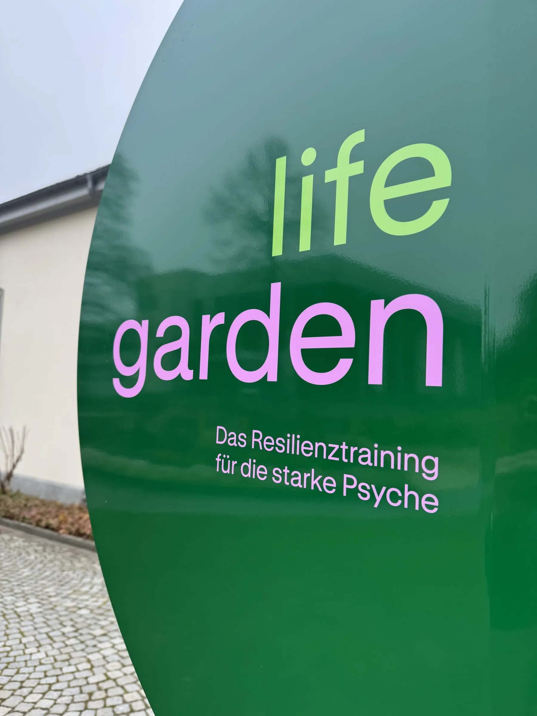 Nahaufnahme des grünen Lifegarden-Schilds mit Schriftzug «Das Resilienztraining für die starke Psyche»