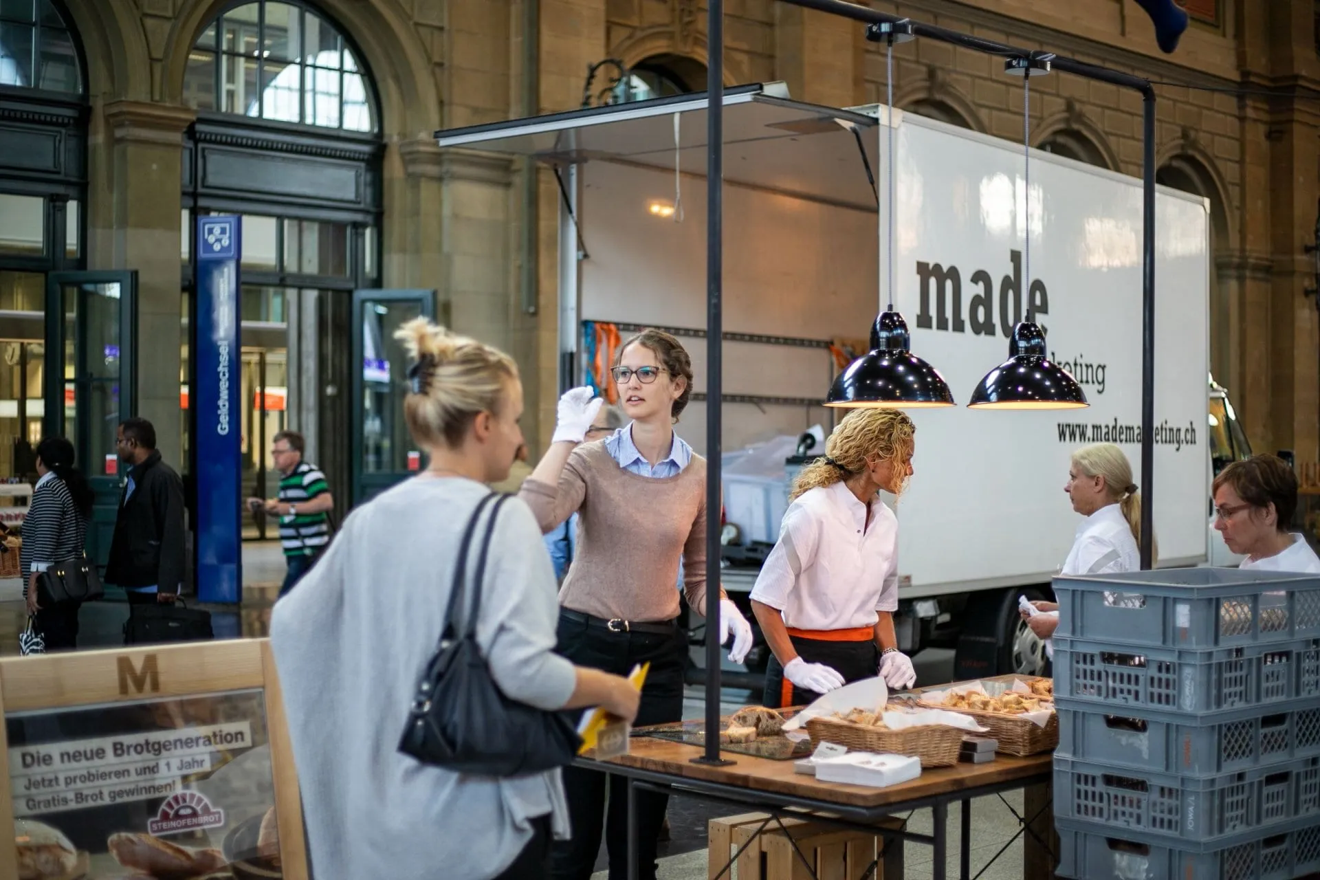 Degustationstisch mit Brothäppchen im Hauptbahnhof Zürich, dahinter der made-Lieferwagen