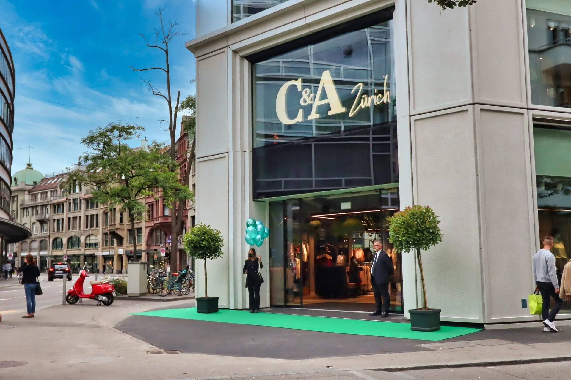 Entrance to C&A on Zürich's Bahnhofstrasse with a green carpet, balloons and a member of the promotional team
