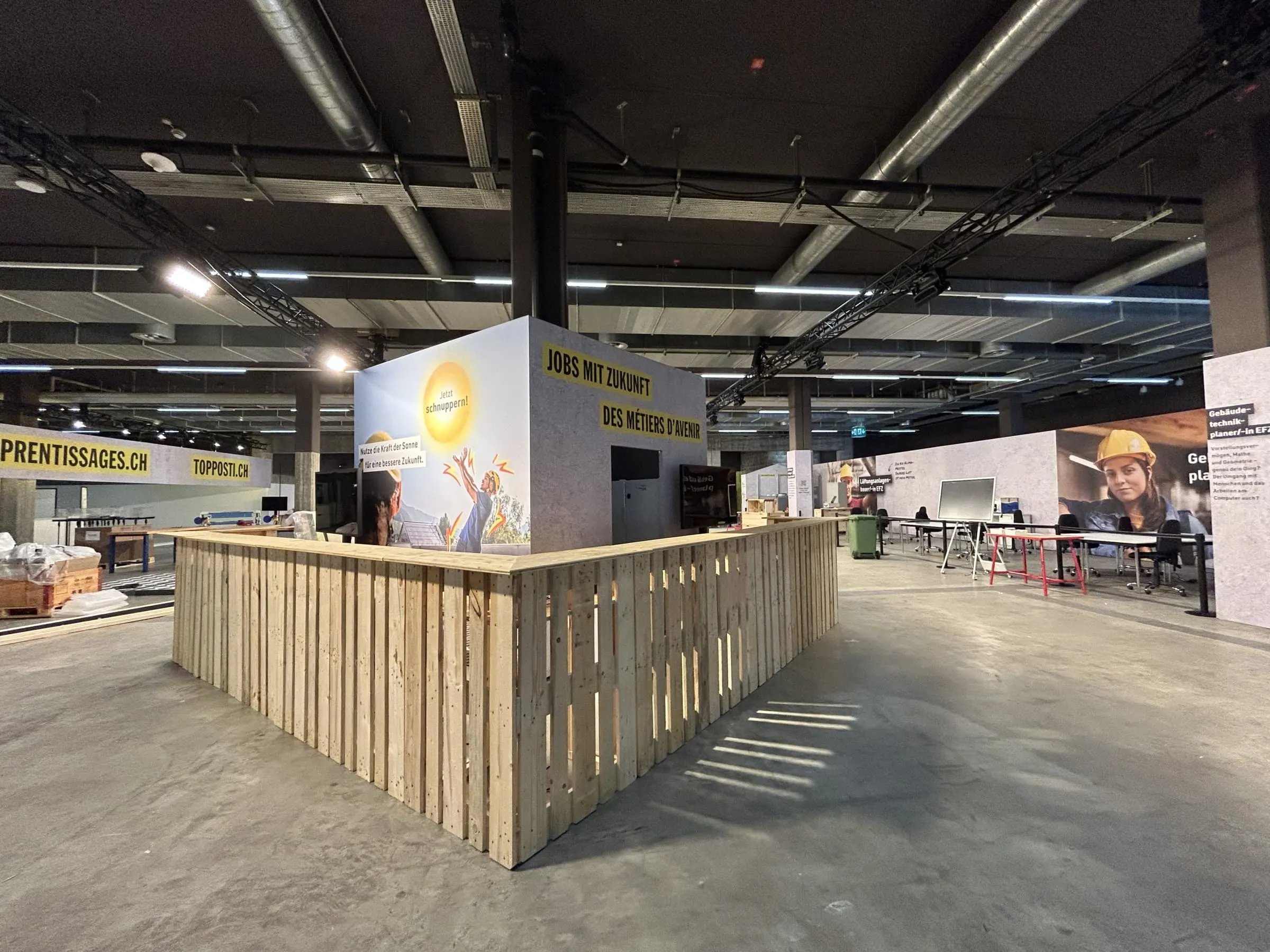 Pallet bar in front of a cube labelled «Jobs mit Zukunft» and «Jetzt schnuppern!» in the exhibition hall