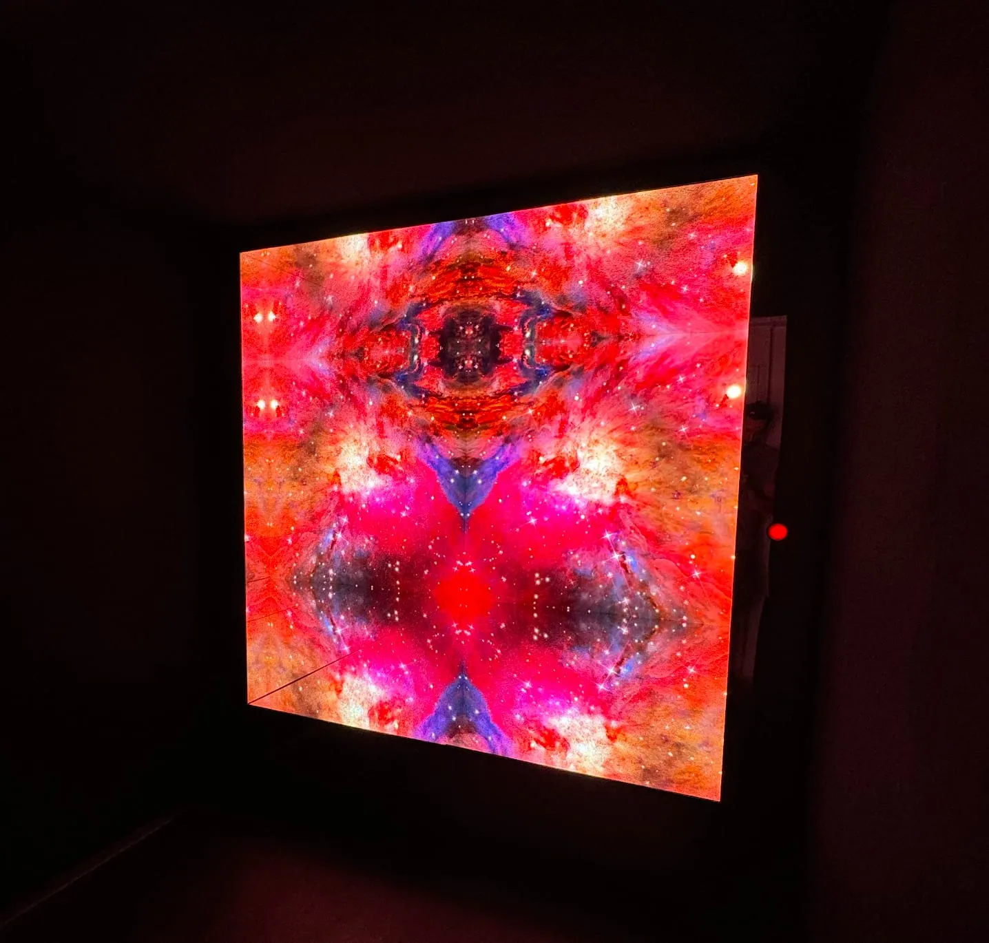 Infinity-Spiegel mit rot-violettem Sternennebel in einem dunklen Raum