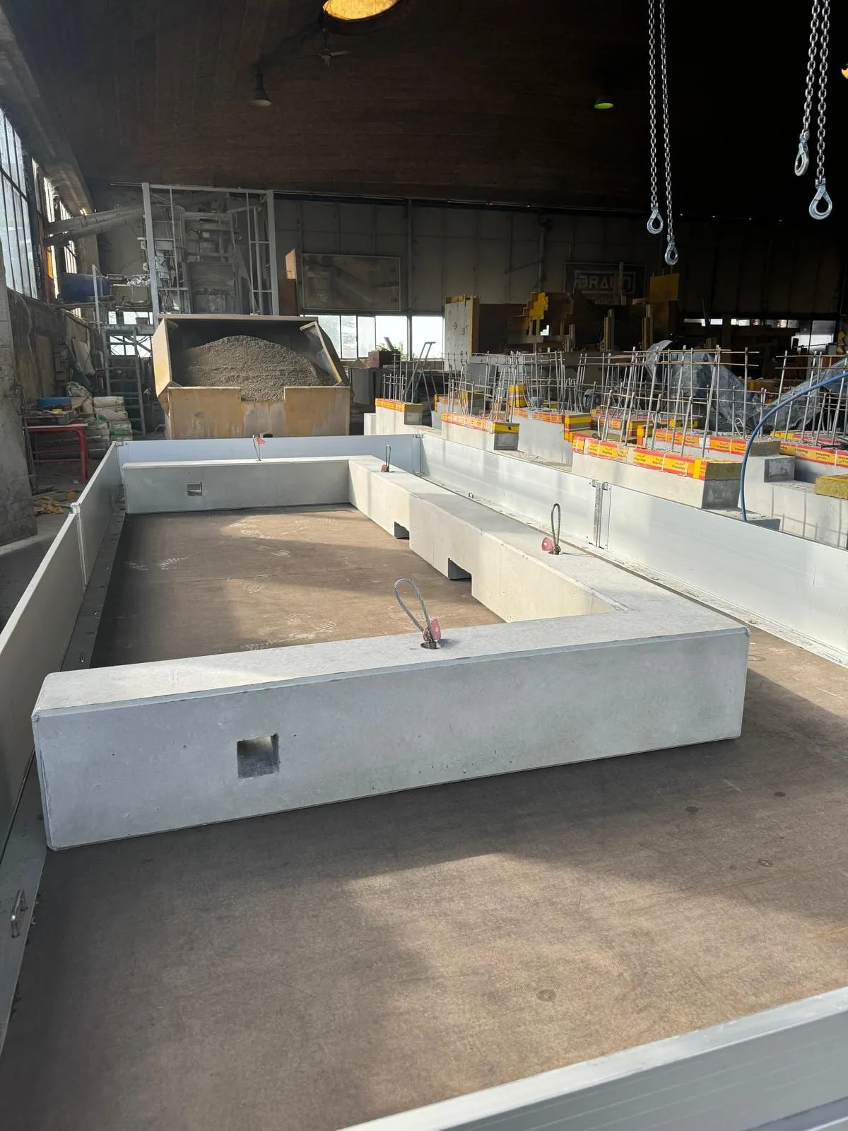 U-förmiges Betonfundament mit Hebeösen auf einem Anhänger in der Betonwerkhalle