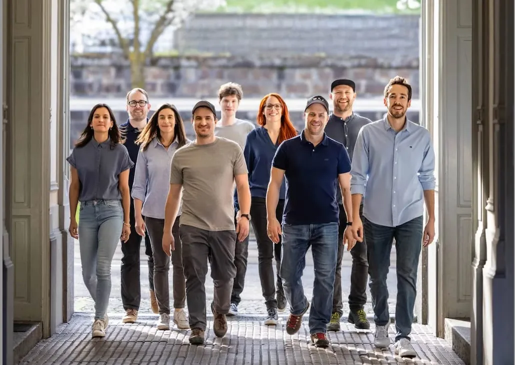 Das made-Team geht durch einen Torbogen auf die Kamera zu