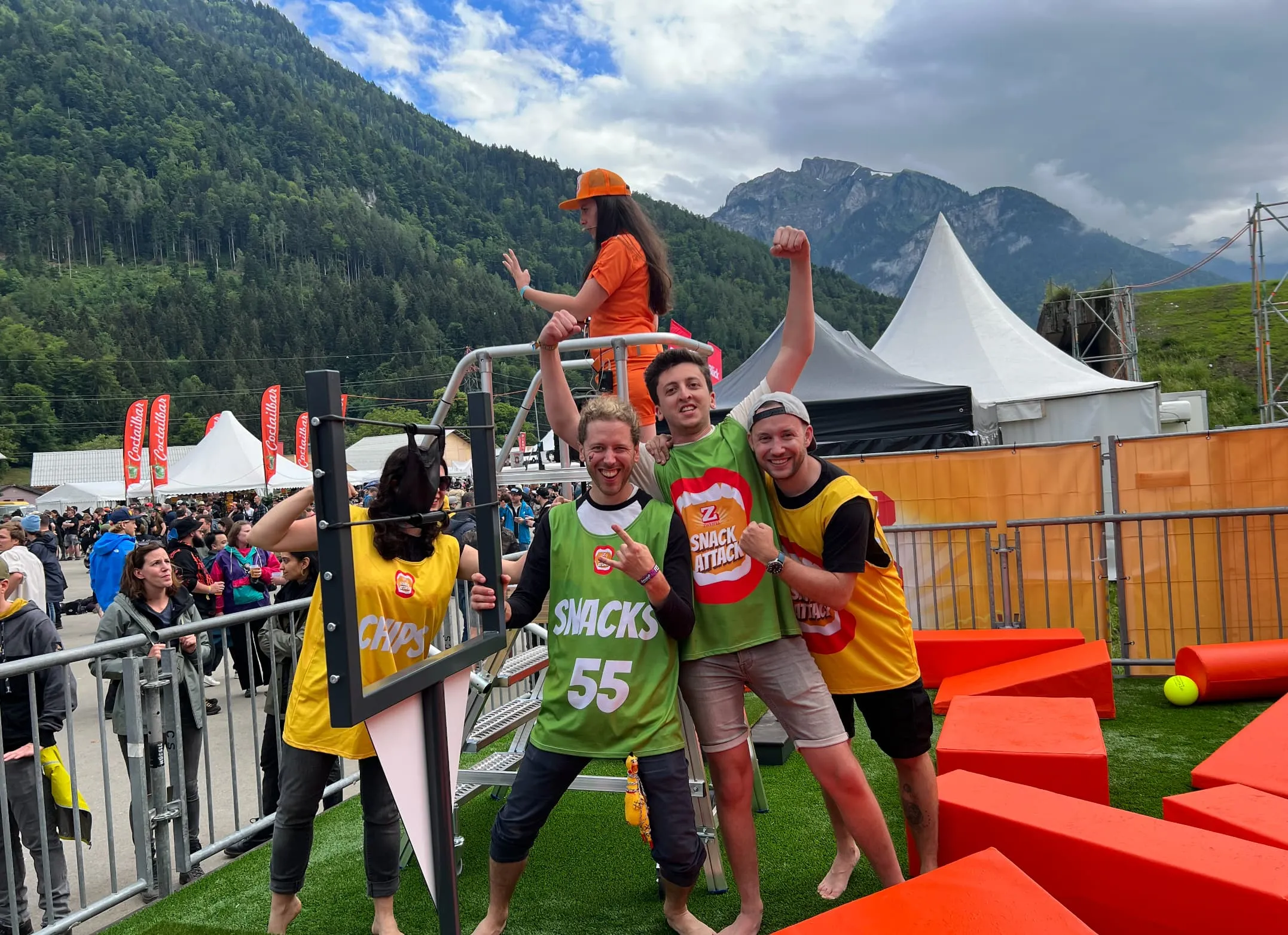 Vier jubelnde Spieler in gelben und grünen Team-Leibchen vor der Bergkulisse des Greenfield Festivals