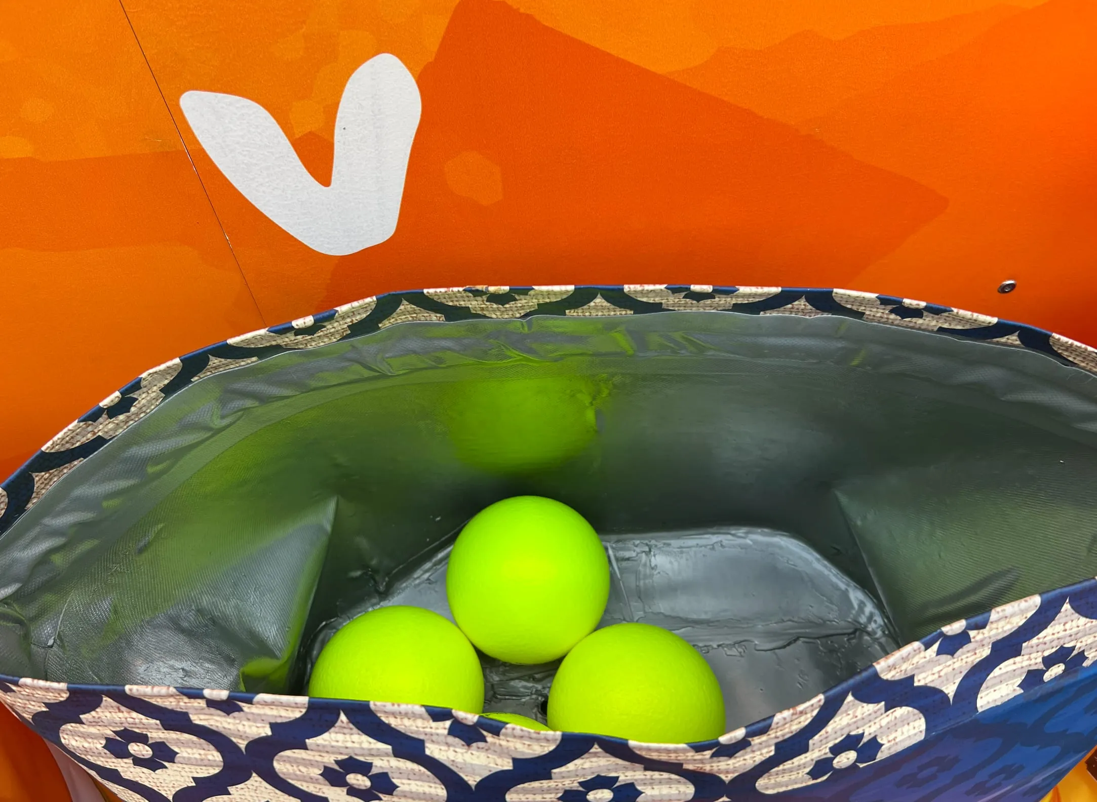 Blick in die offene Riesen-Snacktüte mit drei neongelben Softbällen darin