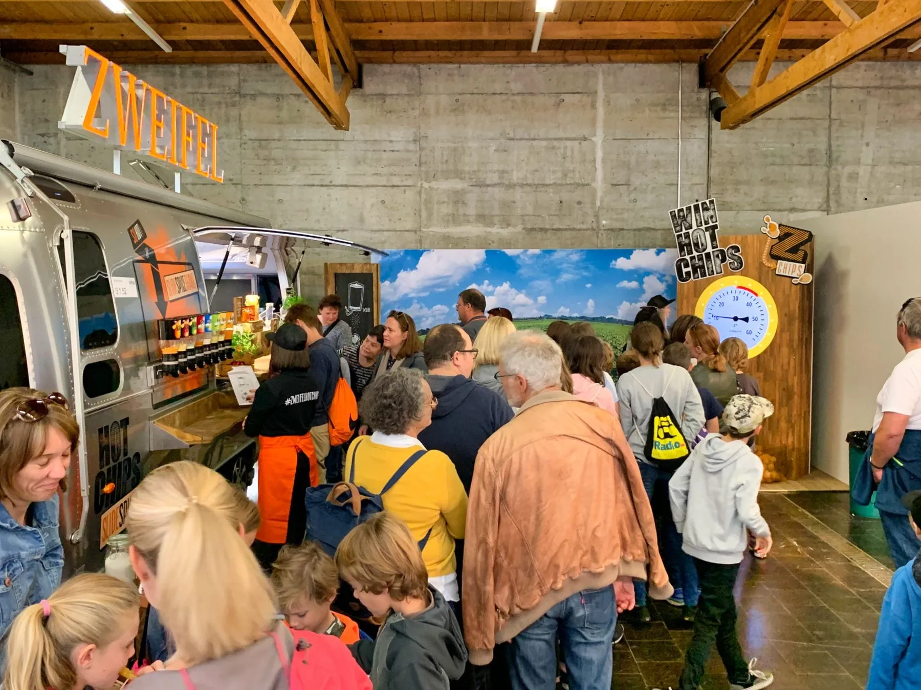 Zweifel-Airstream mit Chips-Ausgabe, Warteschlange und die Hot-Chips-Machine mit Temperaturanzeige am Messestand